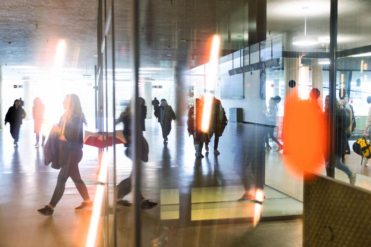 Mensen in ruimte van glazen wanden in oranje gloed