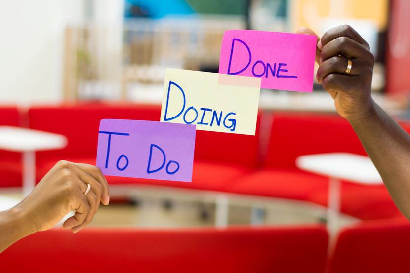 Post-its in handen met de tekst 'To Do - Doing - Done'