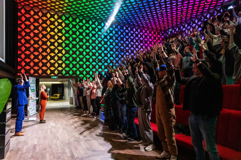 Publiek uit zaal staat met handen in de lucht tijdens afsluiting door De Speld