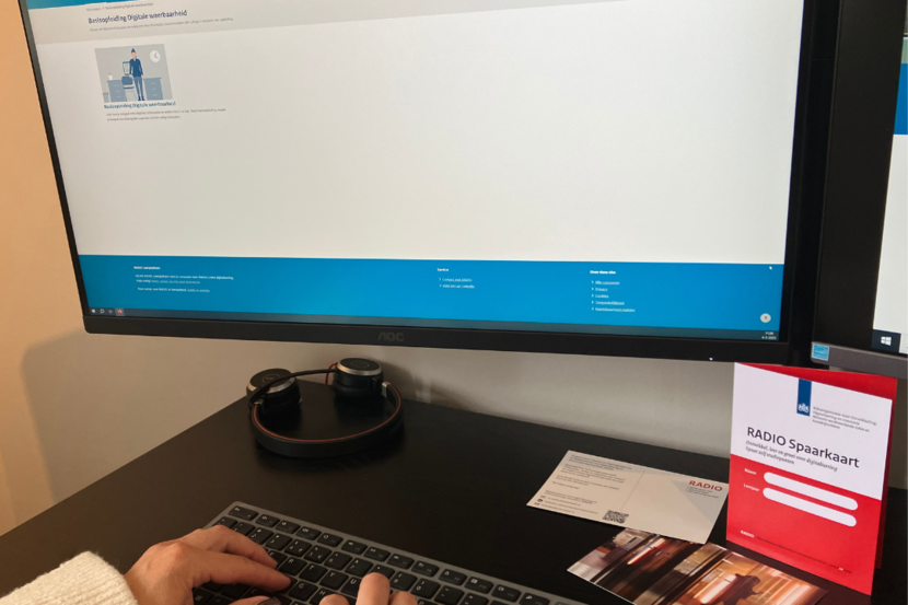 Persoon achter bureau met computer start via RADIO Leerplatform de basisopleiding Digitale weerbaarheid